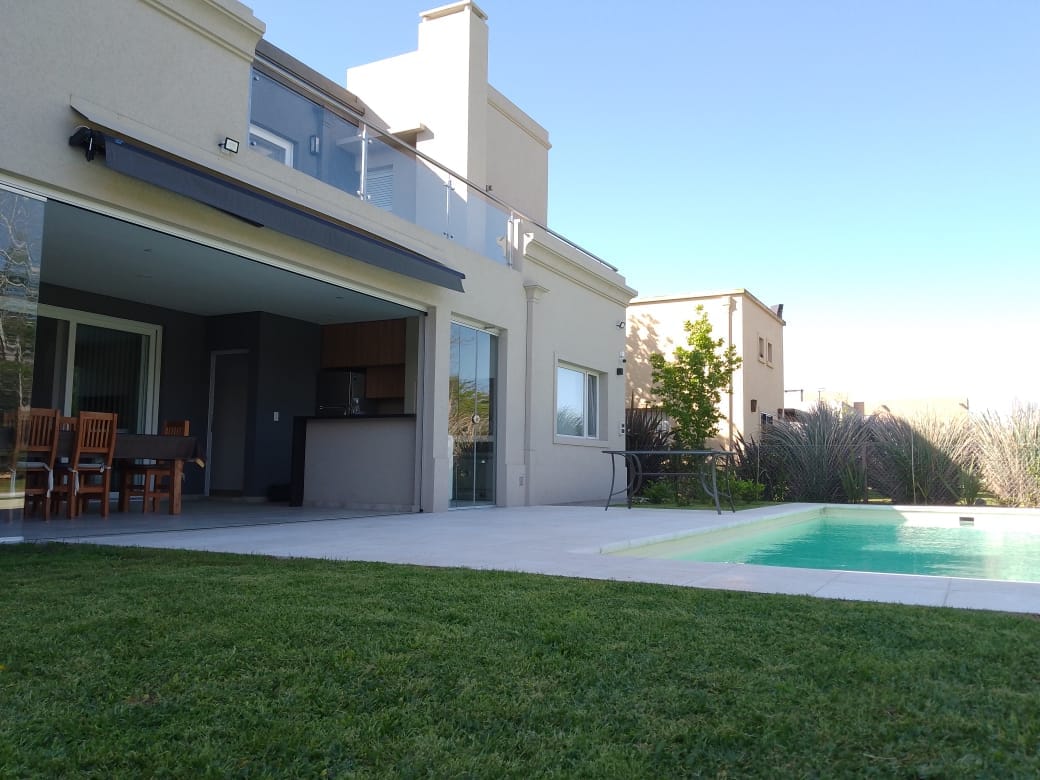 Baranda de vidrio y acero inoxidable en balcón exterior junto a pileta