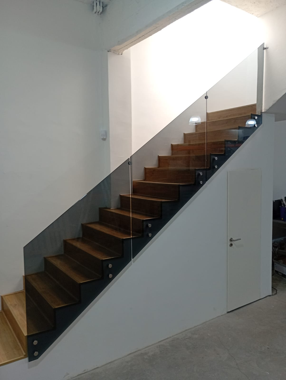 Escalera con estructura metálica y baranda de vidrio a medida