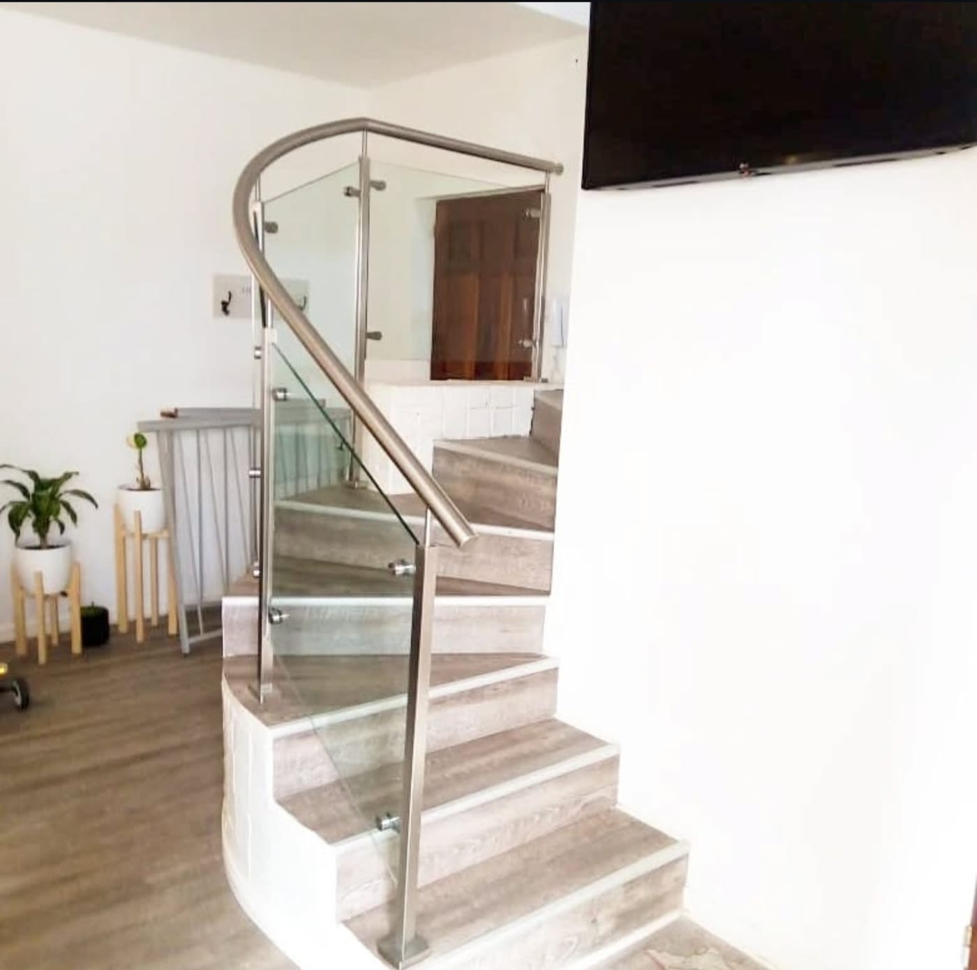 Pasamanos curvo de acero inoxidable con baranda de vidrio en escalera interior
