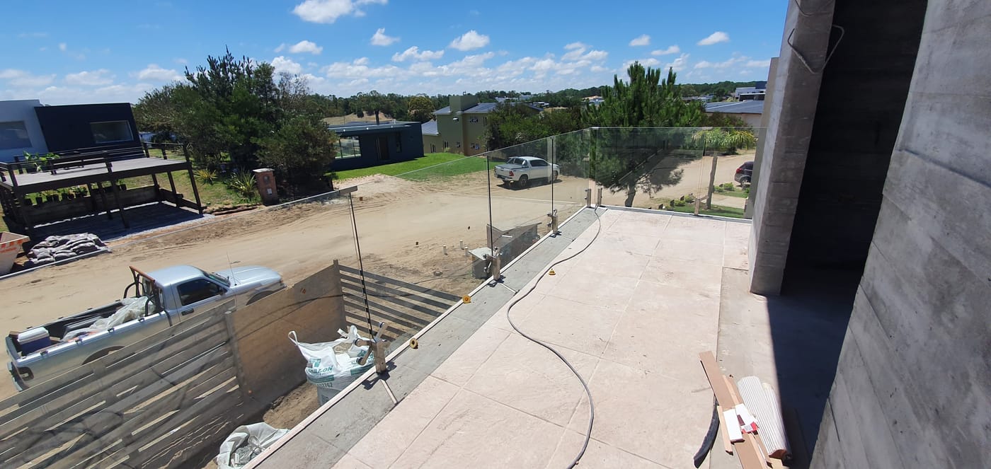 Terraza con baranda de vidrio templado y vista al entorno costero