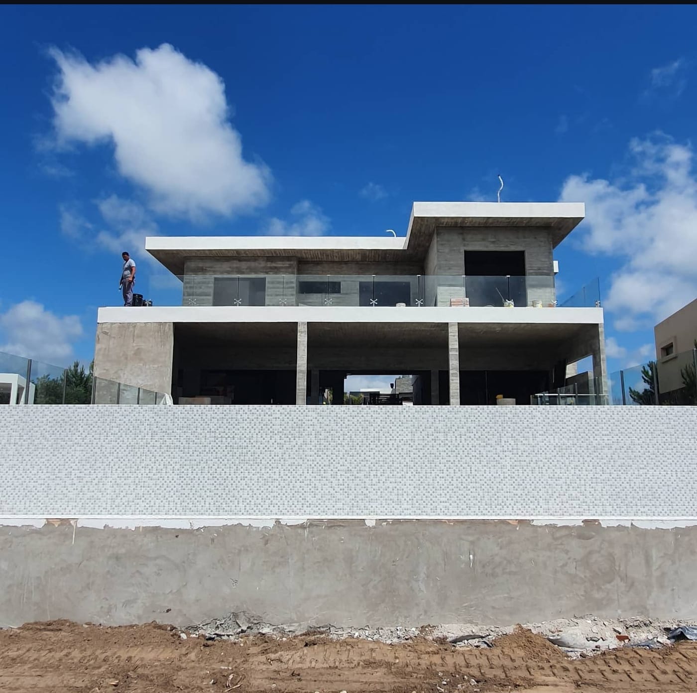 Detalle de baranda de acero inoxidable y vidrio templado bajo losa de hormigón