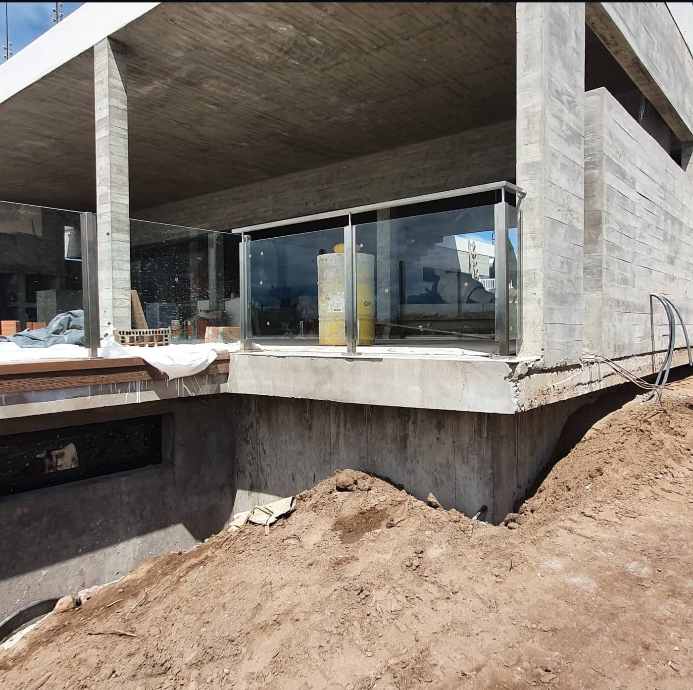 Estructura de acero inoxidable y vidrio templado en balcón de vivienda costera