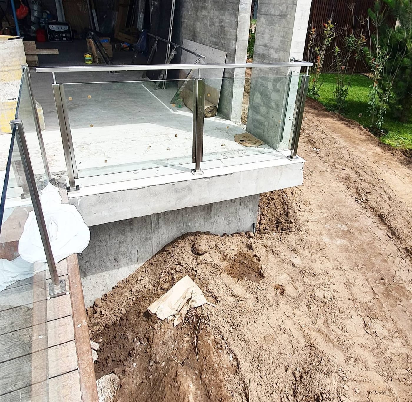 Baranda de acero inoxidable y vidrio templado junto a jardín en Costa Esmeralda