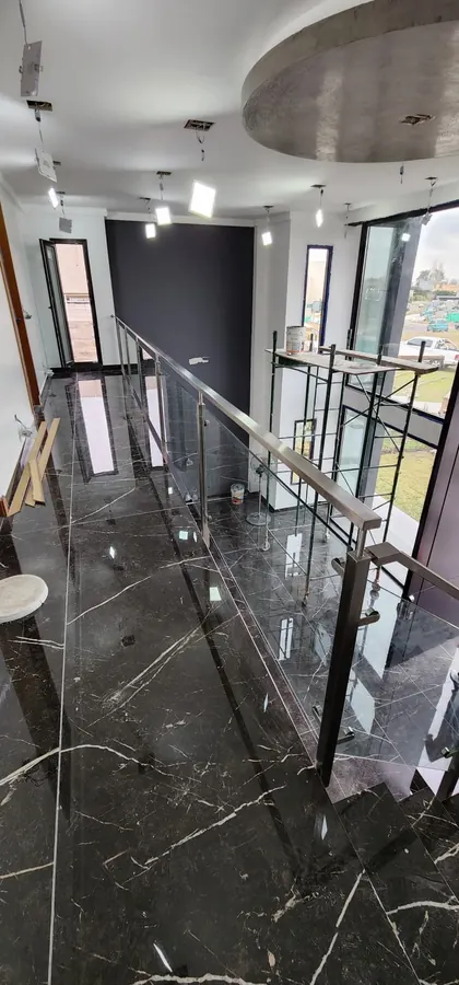 Baranda de acero inoxidable y vidrio en una vivienda de Haras Santa María