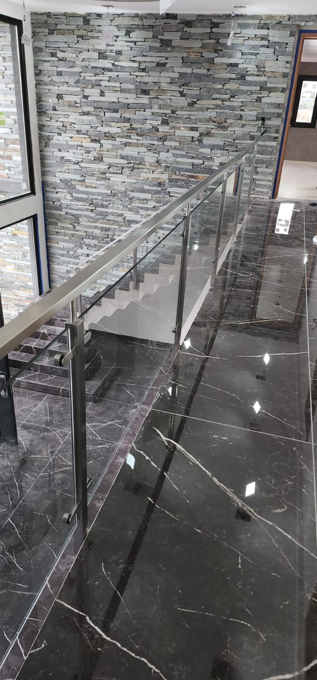 Detalle de baranda de acero inoxidable con vidrio en entrepiso de vivienda