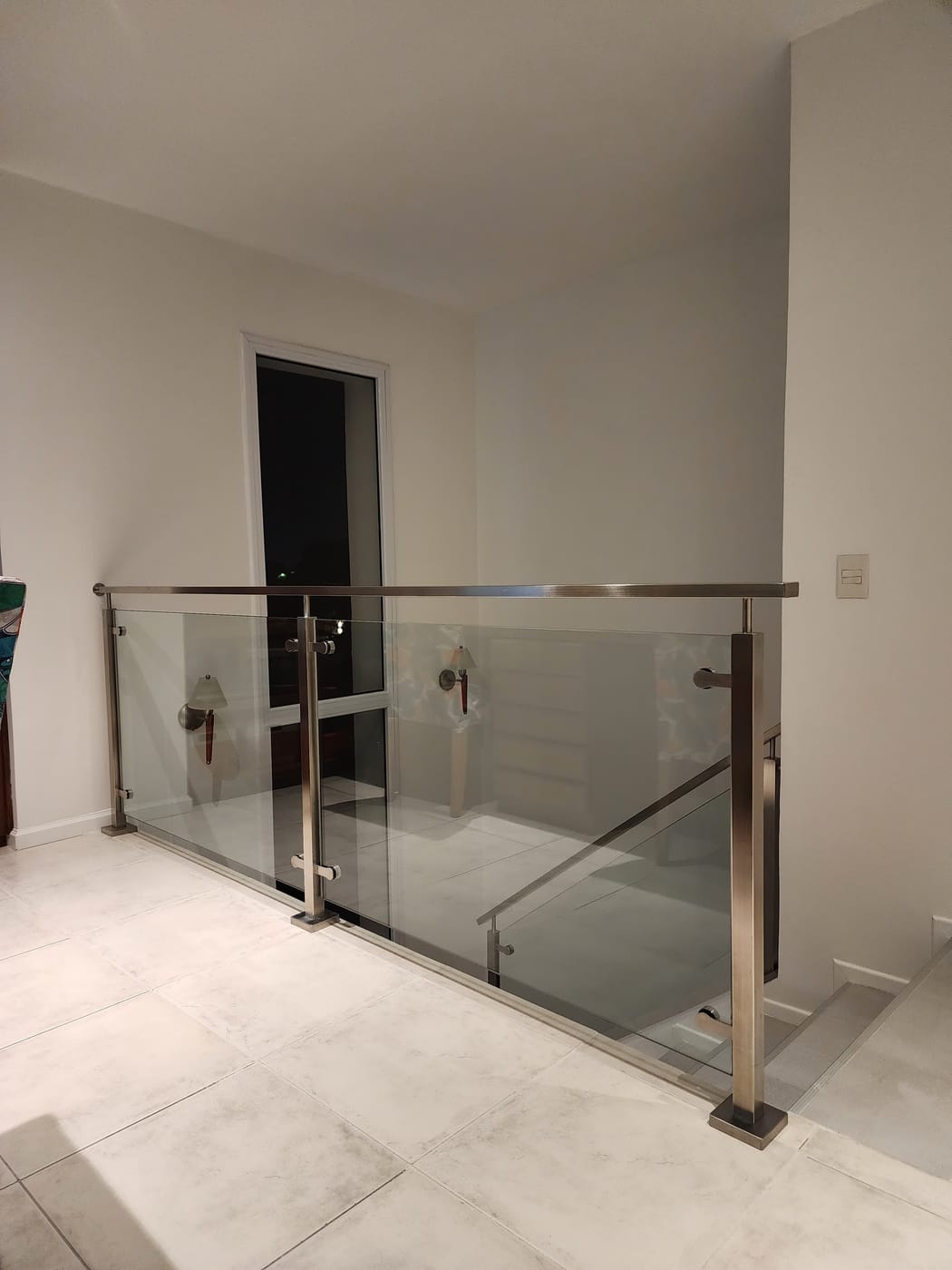 Baranda de vidrio templado con estructura de acero inoxidable en vivienda