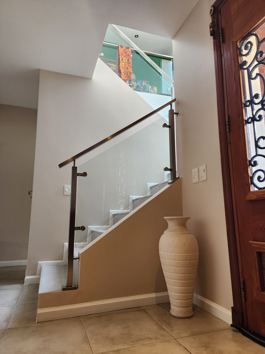 Baranda de acero inoxidable y vidrio en escalera de vivienda en Talar del Lago 2