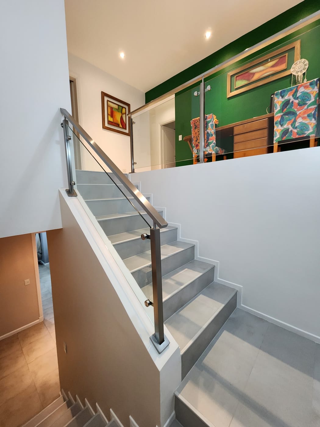 Estructura de acero inoxidable con vidrio templado en entrepiso de vivienda