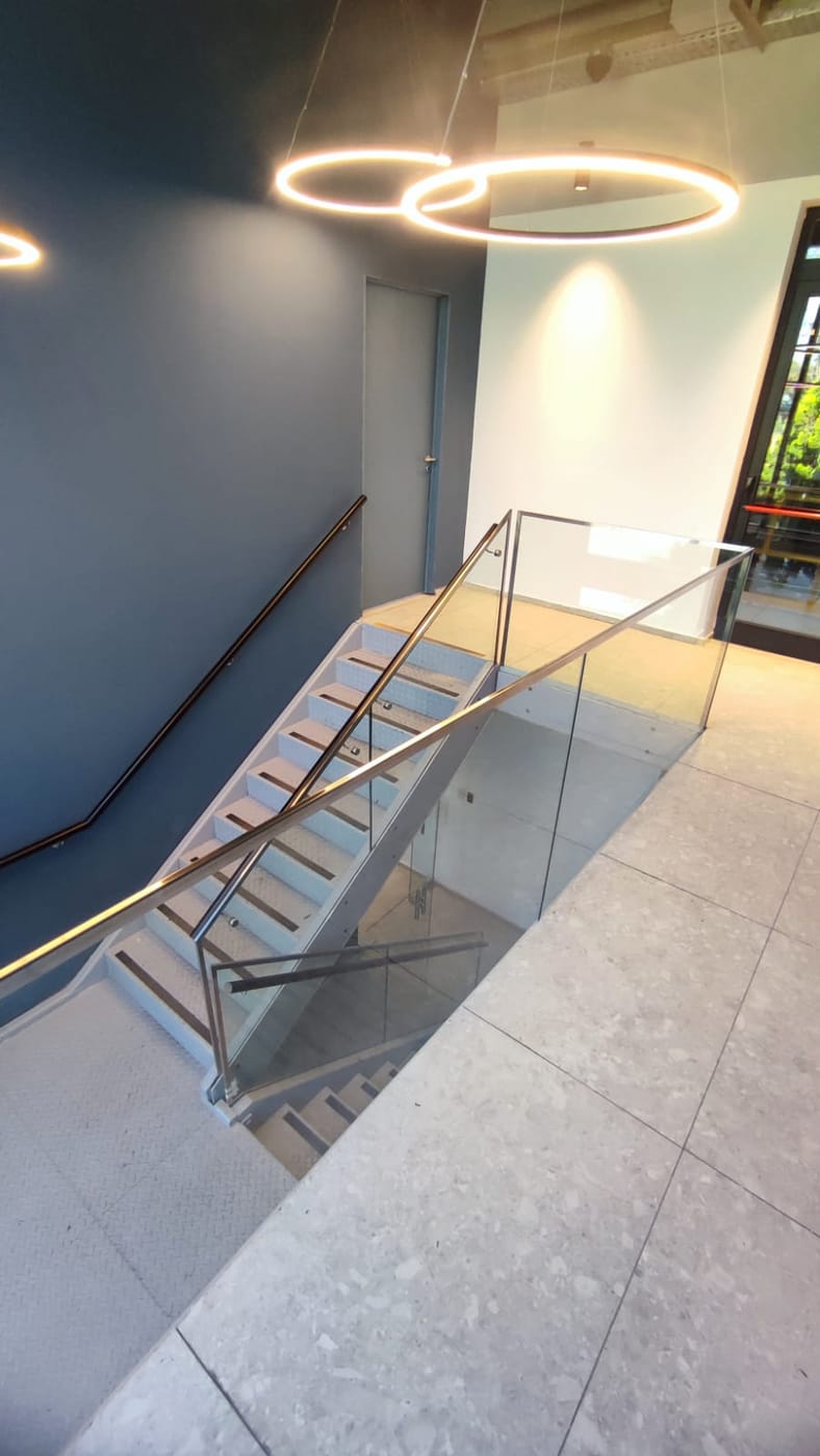 Baranda de vidrio templado con estructura de acero inoxidable en escalera