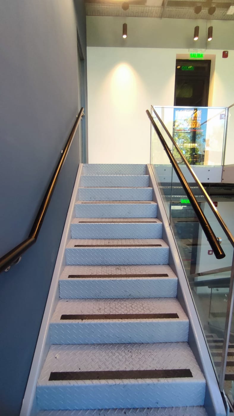 Baranda de acero inoxidable y vidrio en escalera de edificio corporativo