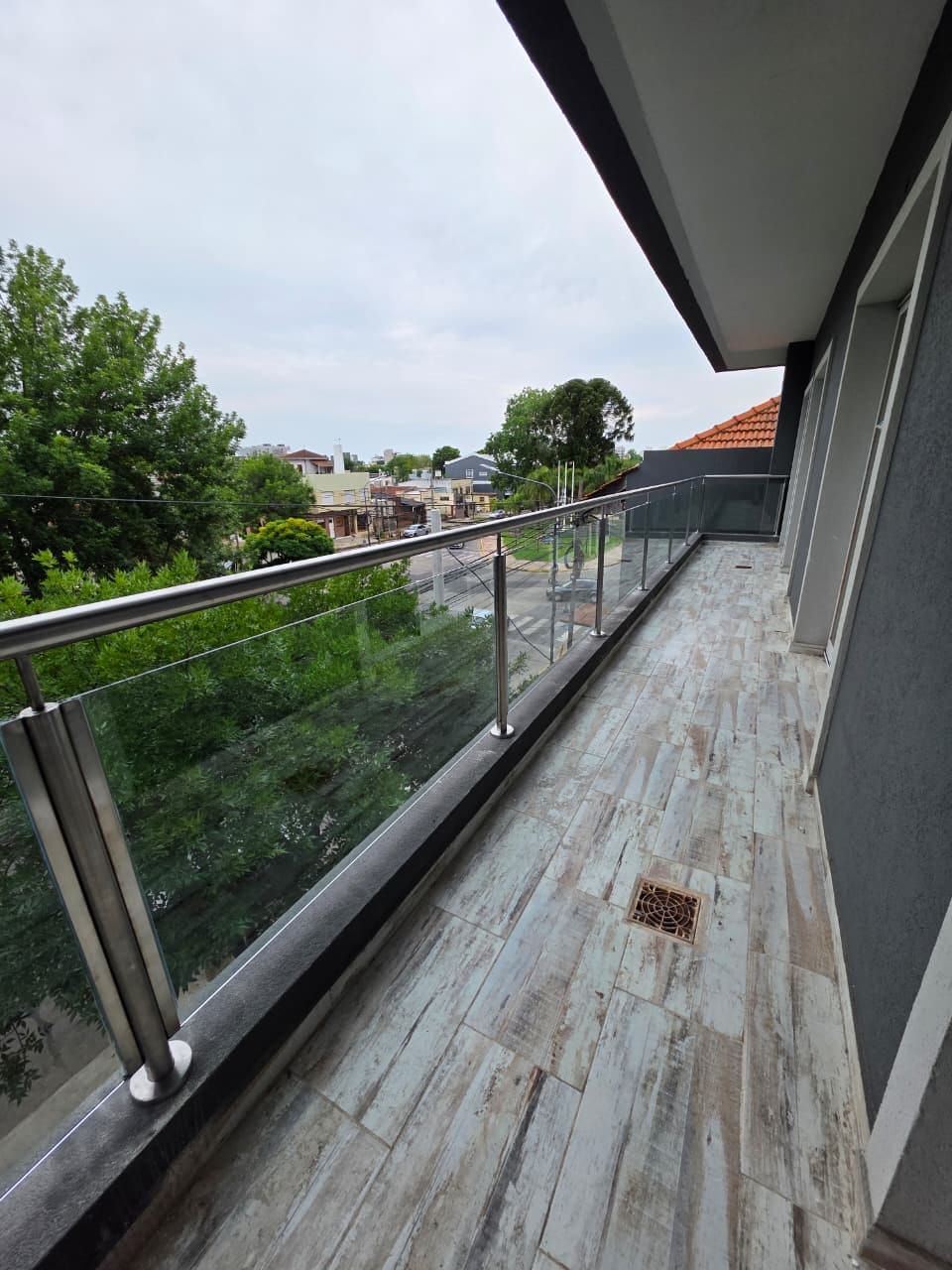 Detalle de baranda de vidrio con estructura de acero inoxidable en Tigre