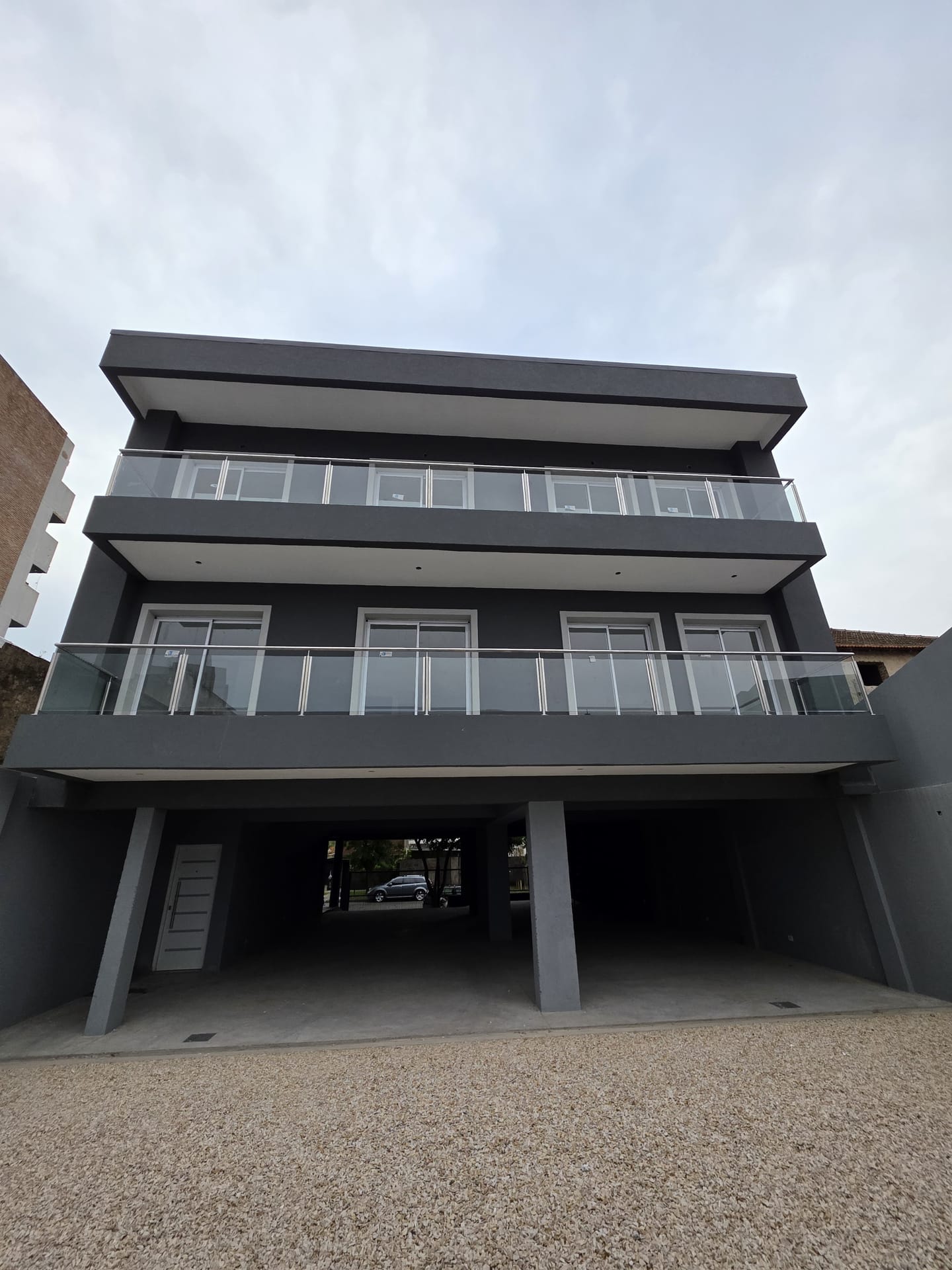Fachada de edificio en Tigre con barandas de vidrio en los balcones