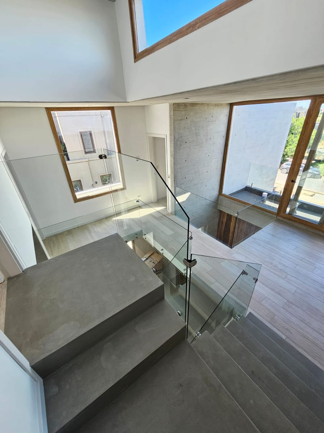 Vista superior de escalera con baranda de vidrio templado y botones de acero inoxidable