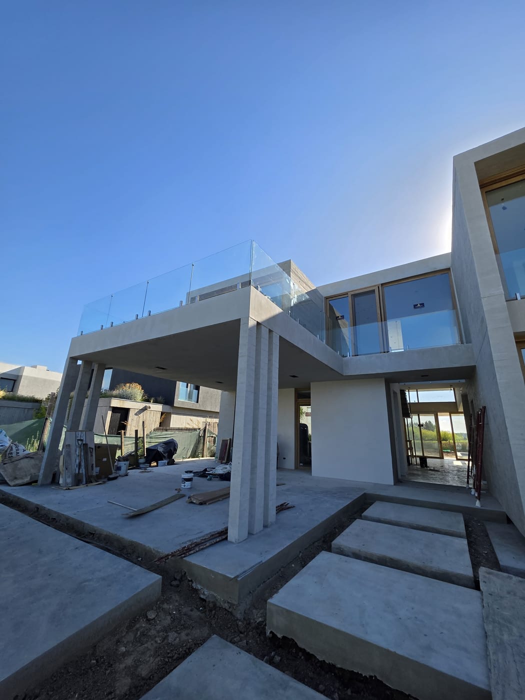 Vivienda moderna con barandas de vidrio y minipostes en balcones exteriores
